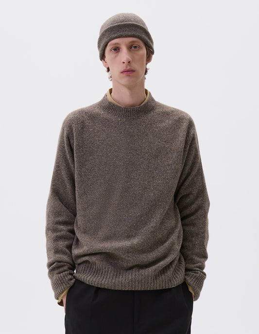 Cropped body image, front view of model wearing beige marl long sleeve jumper with contrast rib neckline, cuffs and hem. Styled over a yellow shirt, black trousers and with matching knitted hat.