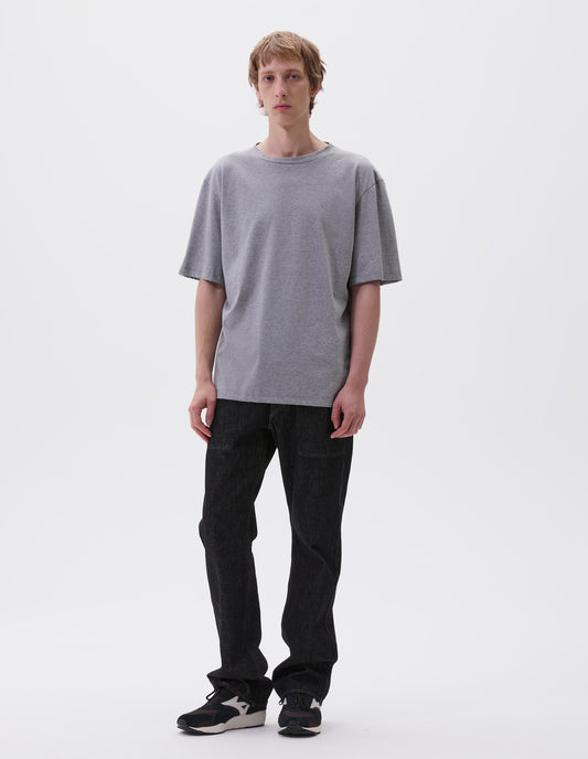 Full body image, front view with grey cotton short sleeve t-shirt. Styled with black denim jeans and black and brown trainers.