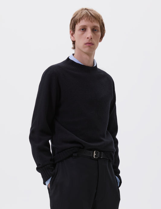 Cropped body image, front view of male model wearing black leather belt with silver buckle and black leather strap. Styled with blue shirt, dark navy jumper and navy trousers.