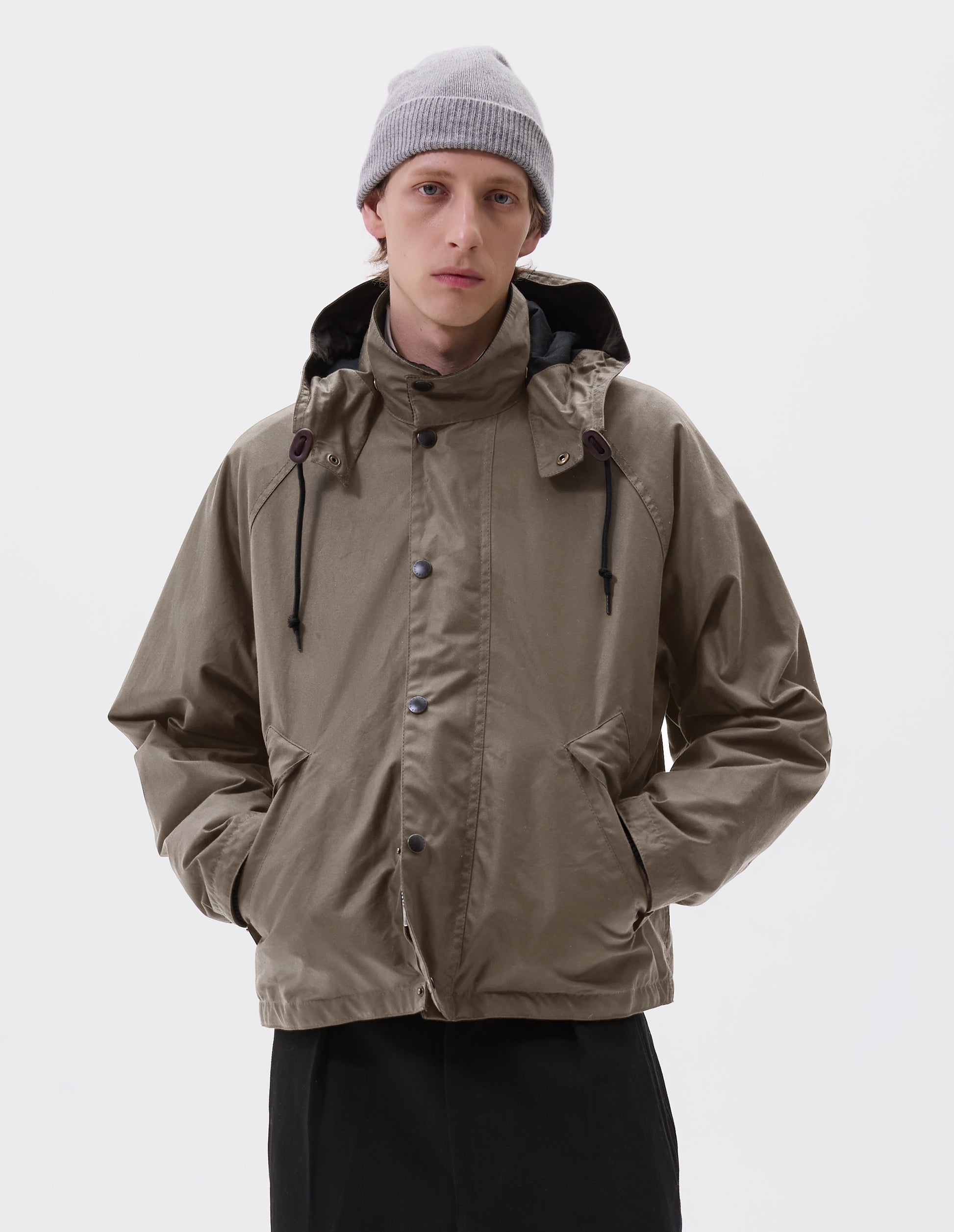 Cropped body image, front view of male model wearing a grey cashmere beanie with contrast rib turn back rim. Styled with khaki beige jacket and black trousers.