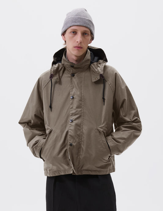 Cropped body image, front view of male model wearing a grey cashmere beanie with contrast rib turn back rim. Styled with khaki beige jacket and black trousers.