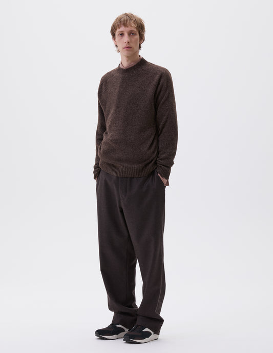 Full body image, front view of model wearing brown marl long sleeve jumper with contrast rib neckline, cuffs and hem. Styled with brown trousers, pink shirt and brown and black trainers.