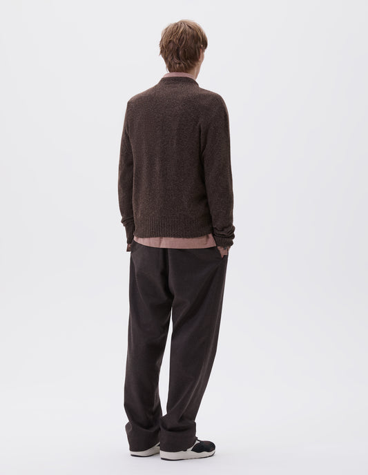 Full body image, back view of model wearing brown marl long sleeve jumper with contrast rib neckline, cuffs and hem. Styled with brown trousers, pink shirt and brown and black trainers.
