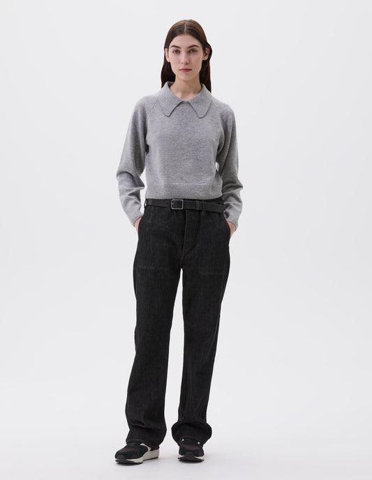 Full body image, front view of model wearing grey cropped collared jumper with contrast rib on cuffs and hem. Styled with black jeans, black leather belt and black, brown and white trainers.