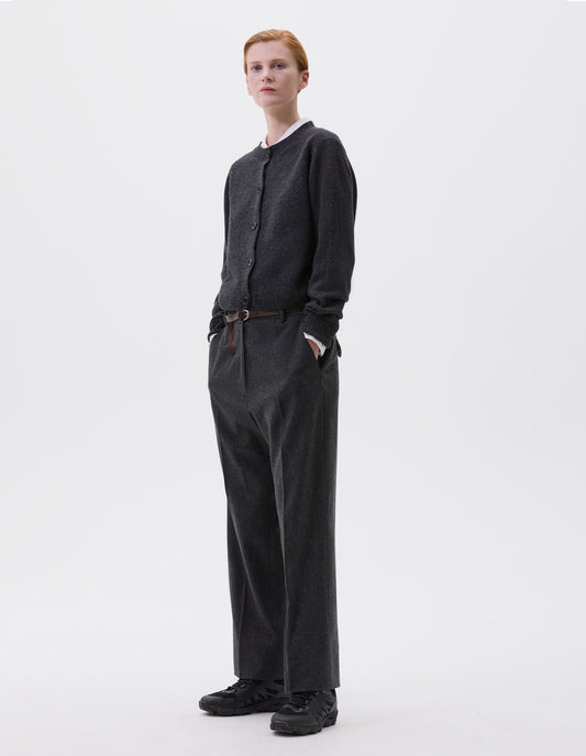 Full body image, front view of model wearing charcoal grey cardigan with contrasting rib neckline, hem and cuffs and dark horn buttons. Styled with white shirt, brown leather belt, charcoal grey trousers and black trainers. 