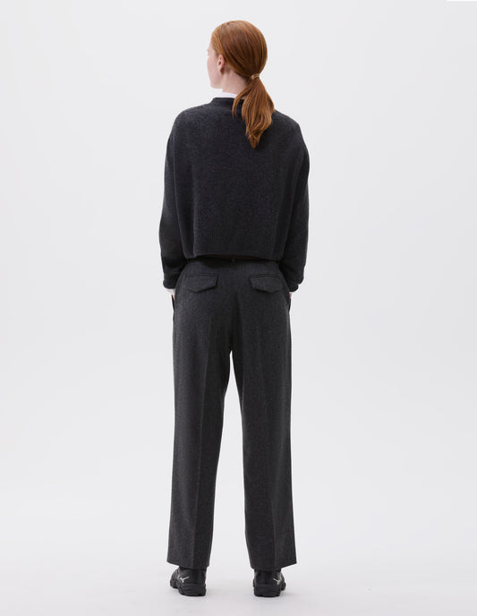 Full body image, back view of model wearing charcoal grey cardigan with contrasting rib neckline, hem and cuffs. Styled with white shirt, charcoal grey trousers and black trainers. 