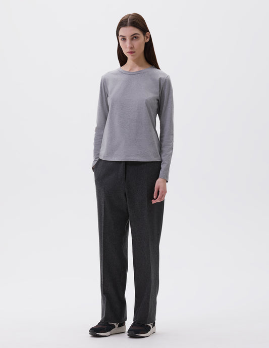 Full body image, front view of model wearing grey cotton wide neck long sleeve with boxy cut. Styled with charcoal grey trousers and black and brown trainers.