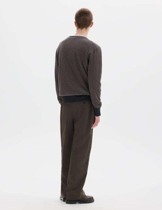Full body image, back view of model wearing grey merino cashmere jumper with dark grey stripes, crew neck with tubular collar, and with contrast rib on cuffs and hem. Styled over white t-shirt and with khaki green trousers and brown leather shoes.
