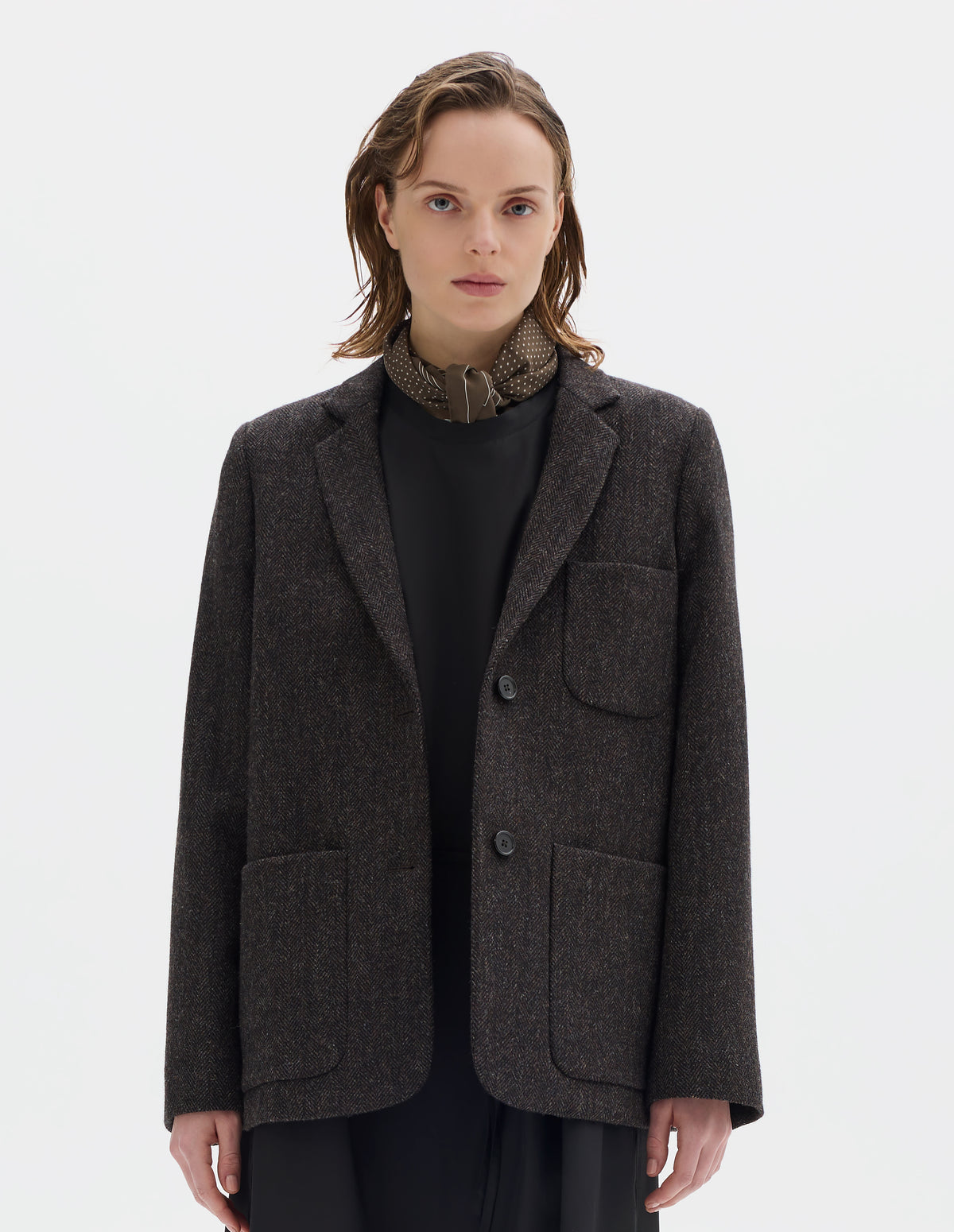 Cropped image, front view of female model wearing khaki green square silk neck scarf with white border stripes with white dots inside and hand rolled edges. Styled with brown blazer and black dress.