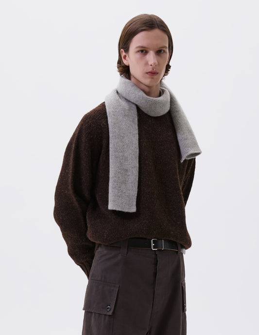 Cropped body image, front view of male model wearing grey knitted wool scarf. Styled with brown jumper, grey trousers and black leather belt.