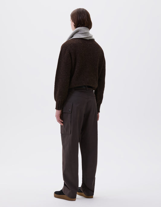 Full body image, back view of model wearing brown cargo trousers with deep flap button fastening patch pocket, belt loops and welt pocket on back yoke. Styled with brown jumper, grey scarf, black leather belt and black suede trainers.