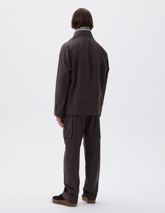 Full body image, back view of model wearing brown raglan sleeve jacket Styled with matching brown trousers, grey scarf and black nubuck trainers. 
