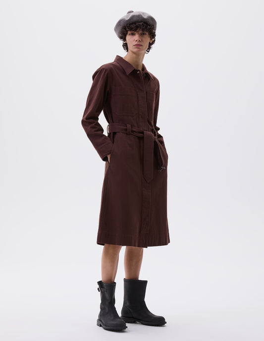 Full body image, front view of female model wearing greyish beige wool tam o shanter hat with matching pom pom bobble in centre. Styled burgundy dress and black leather boots.