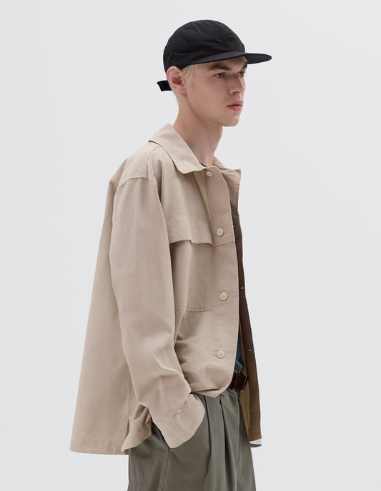 Cropped body image, front view of male model wearing black soft peak cap with contrast herringbone tape slide adjustor detailing. Styled with beige shirt and khaki green trousers.