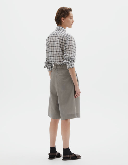 Full body image, back view of model wearing  black and cream stripe regular cut knee length shorts with with half-elasticated waist, slant side pockets and welt back pocket.  Styled with white shirt with black check, black socks and brown leather sandals.
