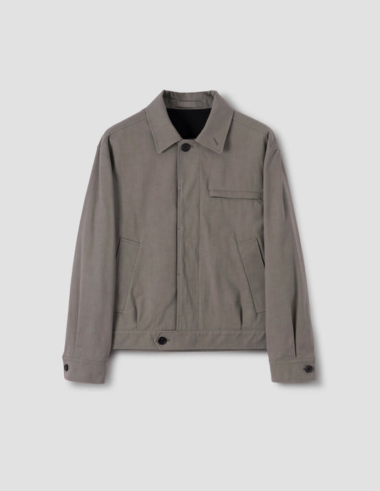 Beige jacket with slant and chest pockets and horn button closure and cuffs, front flat lay view.