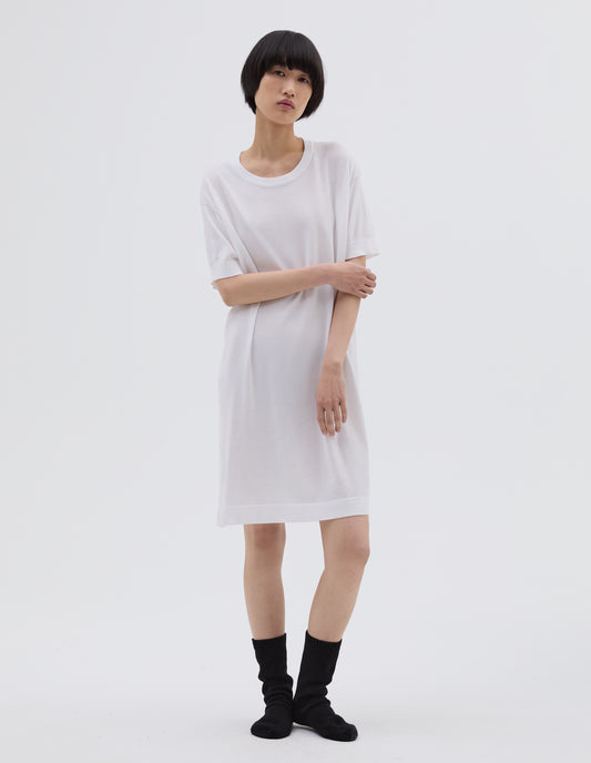 Full body image, front view of model wearing white cotton night t shirt, with short sleeve and round neck. Styled with black bed socks.