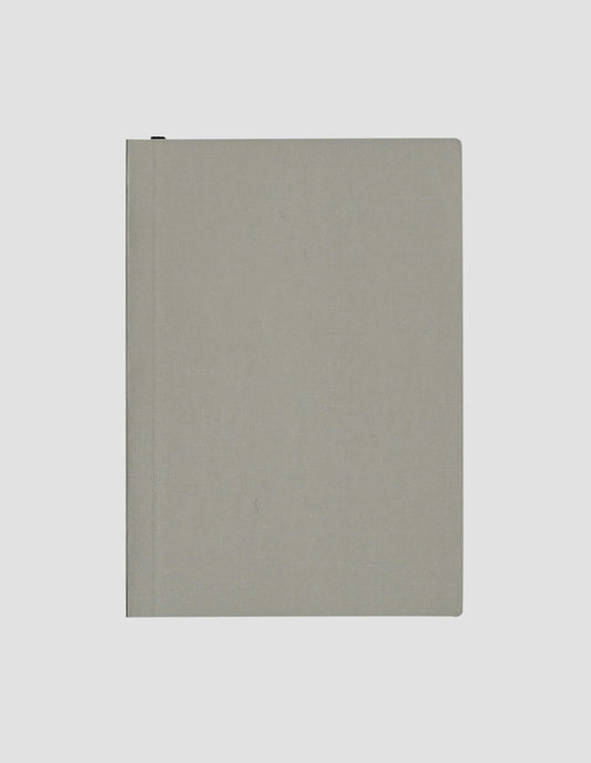 A flat lay view of the grey paper cloth notebook cover with the black ribbon bookmark just visible.
