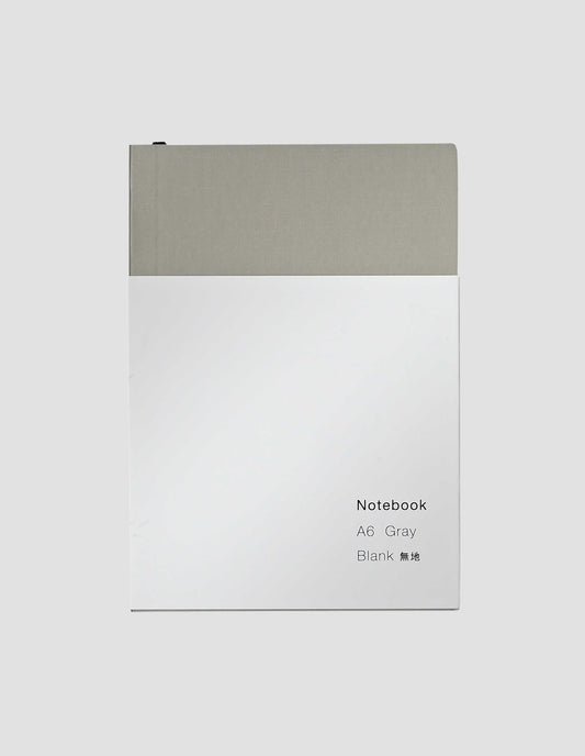 A flat lay view of the grey notebook with white wrap around label and the black ribbon bookmark just visible.