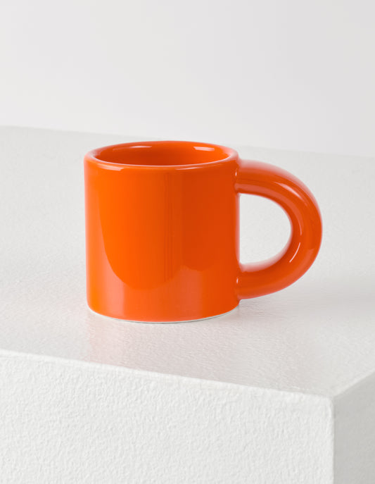 A single orange Bronto espresso cup with the high gloss glaze bringing our attention to the exaggeratedly chunky handle.