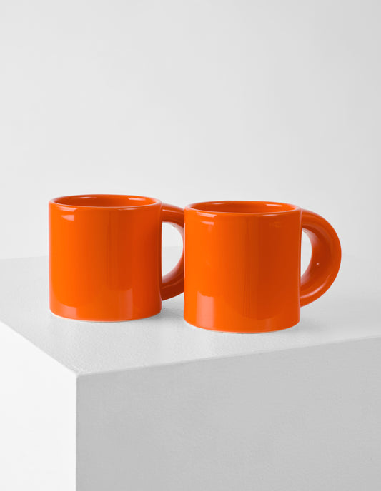 A set of two orange high gloss Bronto mugs with exaggeratedly chunky handles.