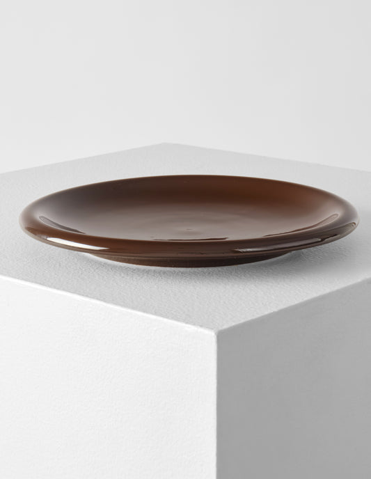 A single brown high gloss stoneware Bronto plate on a white plinth.