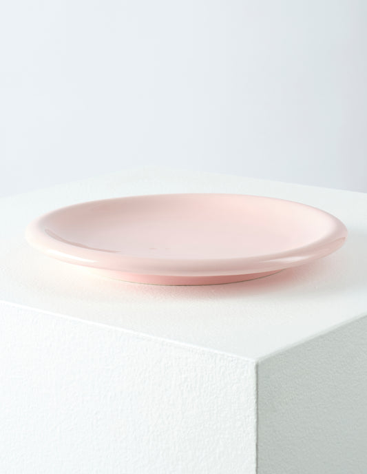 A single pink high gloss stoneware Bronto plate on a white plinth.