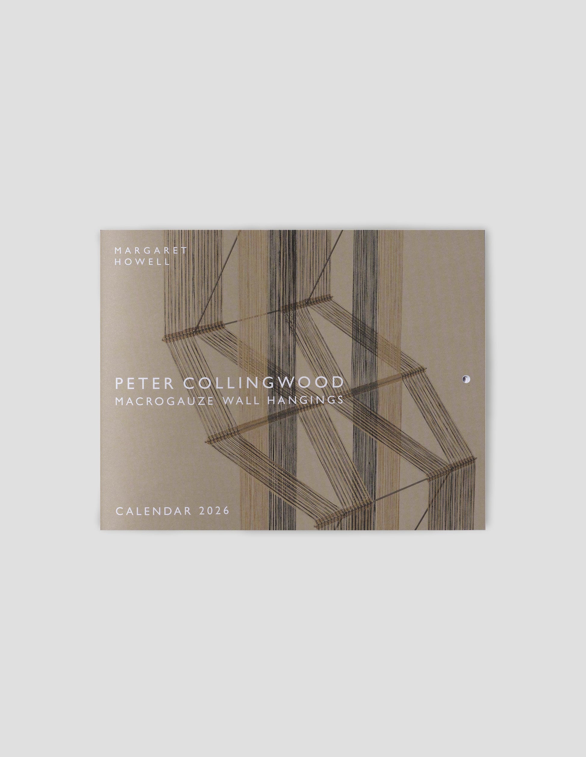 A flat lay view of the cover of the annual calendar with the Margaret Howell logo, the title Peter Collingwood, macrogauze wallhangings, calendar 2026 over a photograph of a three colour weaving.