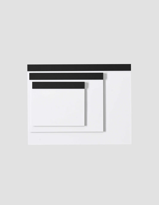 A flat lay view of multiple sizes of the white drawing pad stacked neatly on top of each other in size order.
