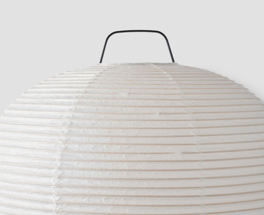 A close up view of the top of the Hotaru mini buoy table light showing the texture of the off white translucent handmade mulberry bark washi paper over the bamboo frame.