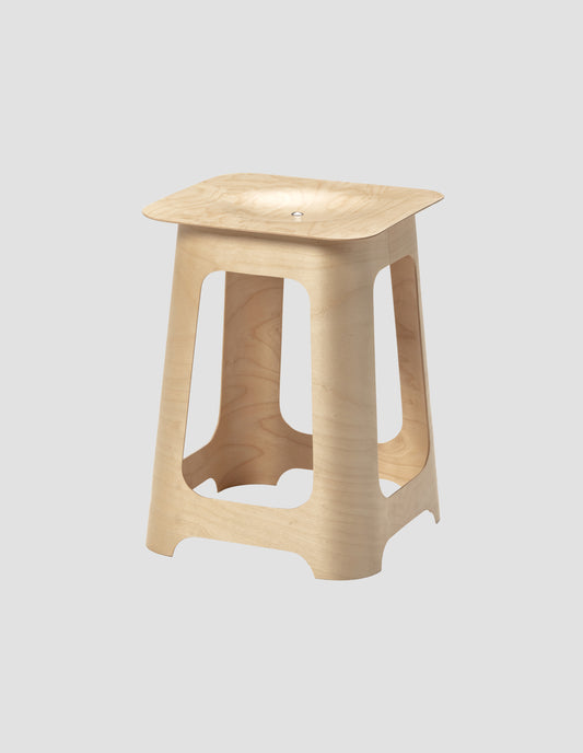 An angled view of the Isokon birch plywood stool showcasing the seat and legs on a white background.