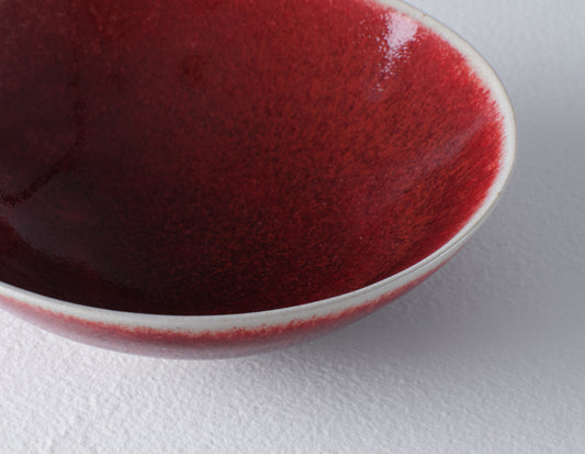 Close up of dark red stoneware small bowl showing the lighter colour rim.