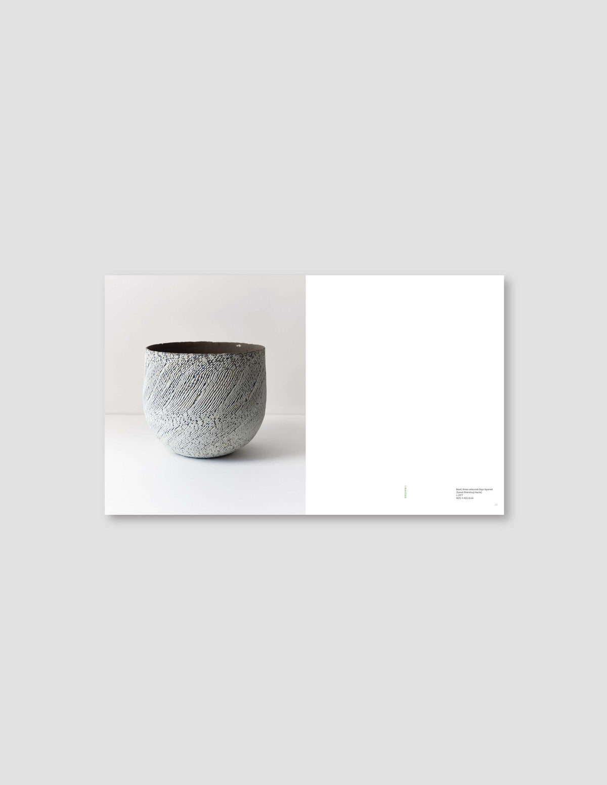 An image from the book featuring a photograph of a grey ceramic artwork on the left side, and a blank page with the artwork details on the right side. Flat lay image on a light grey background.