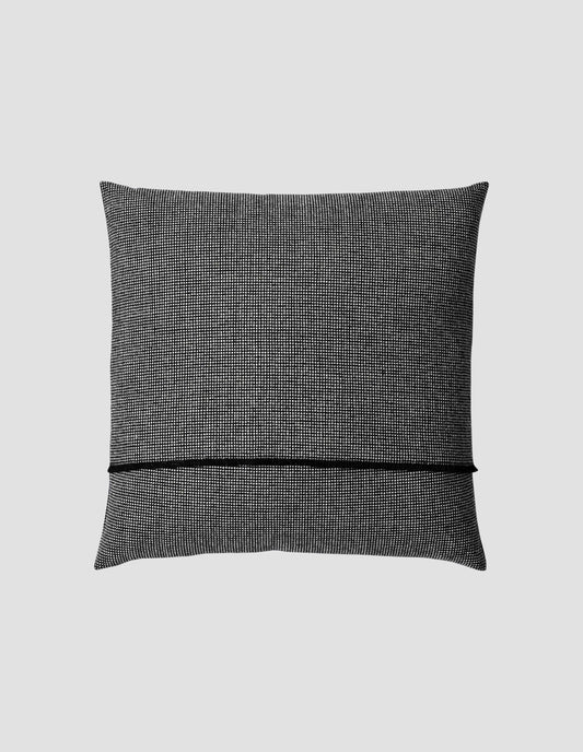 A flat lay view of the handloomed black and white check cushion showing the black warp thread selvedge at the opening for the cushion pad.