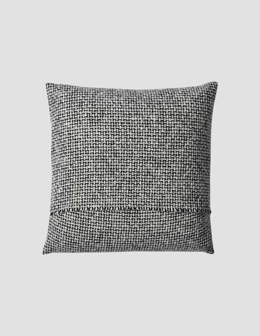 A flat lay view of the handloomed black and white woven cushion showing the warp thread selvedge at the opening for the cushion pad.