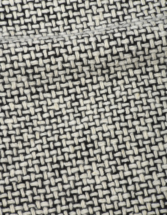 A close up view showing in detail the texture and intricate pattern created by the thick and thin woven black and white yarns.