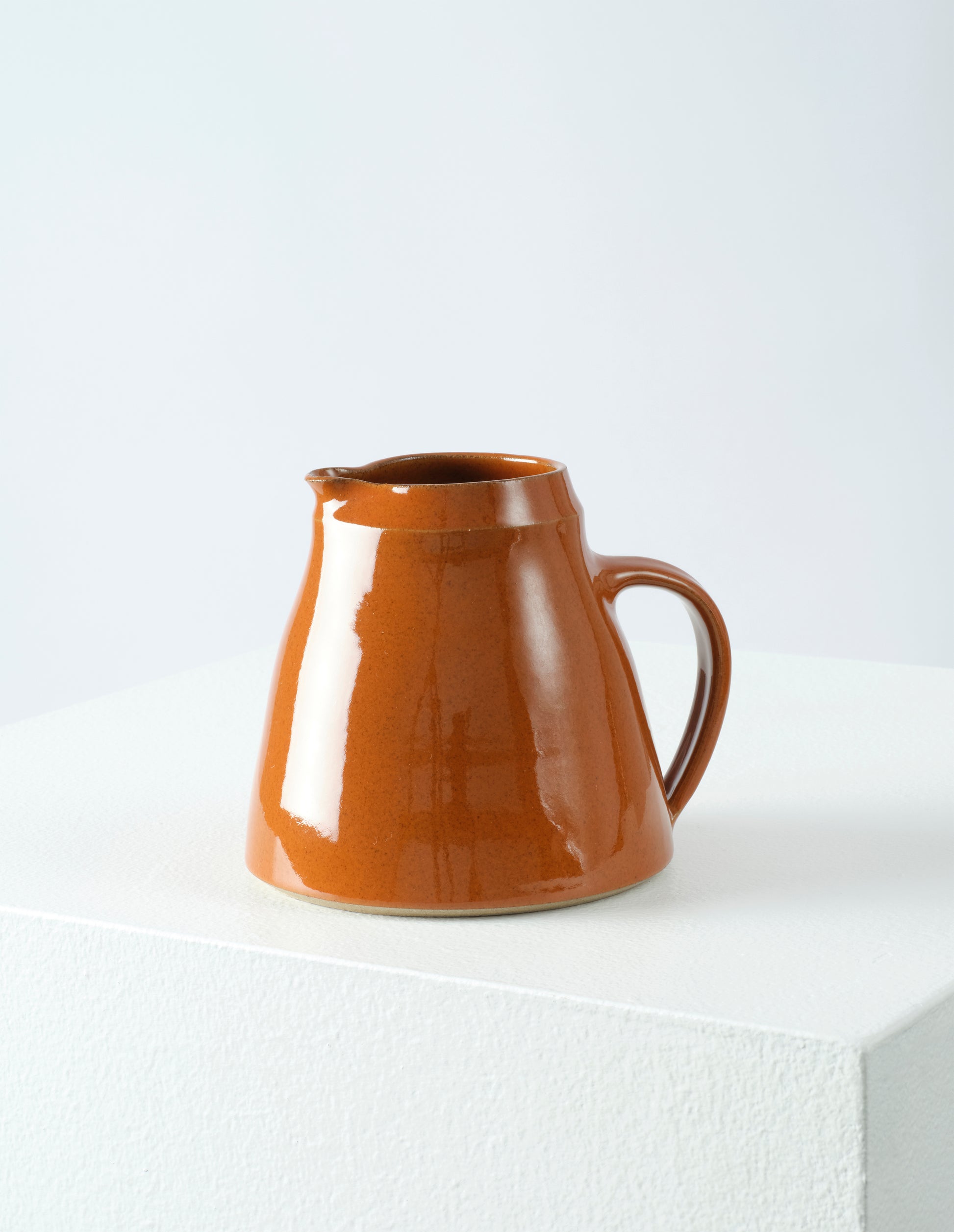 Front view of Nicola Tassie small orange brown glazed stoneware jug.