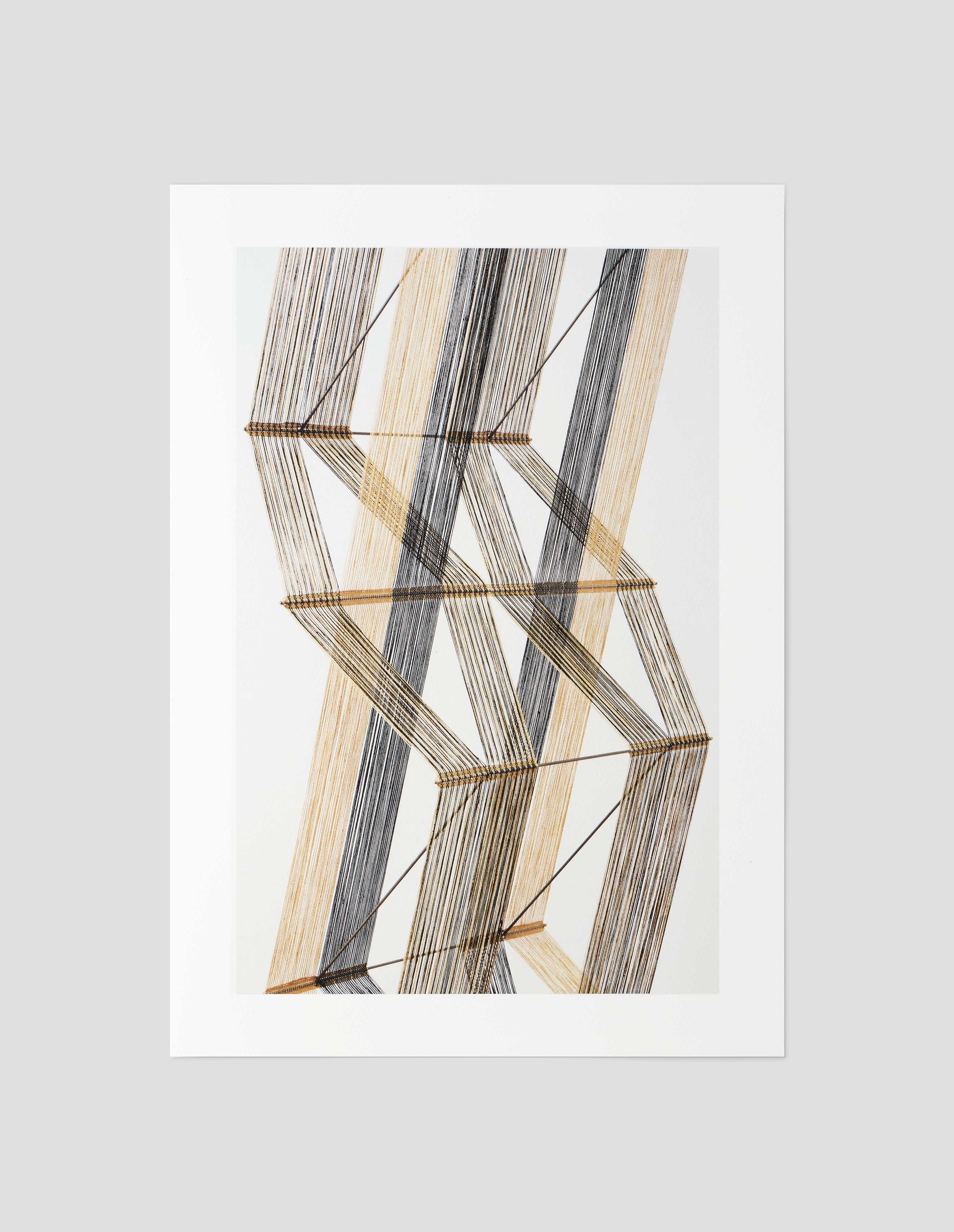 A beige, brown and white print of a Peter Collingwood macrogauze woven wall hanging on a pale background, front flat lay view. 