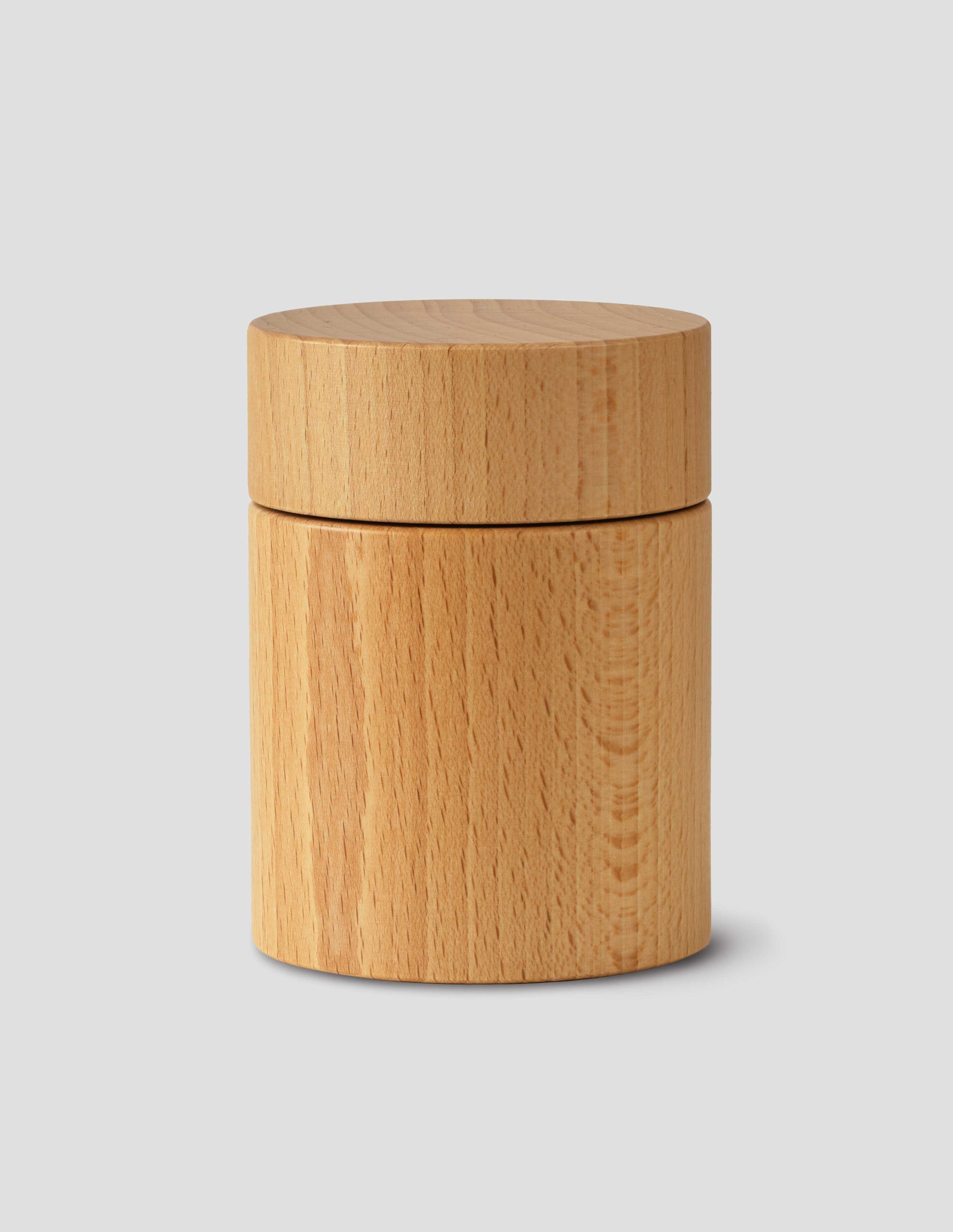 A front flay lay view of a wooden cylindrical salt and pepper mill.