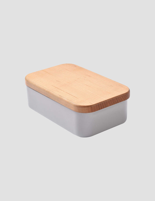 An angled view showcasing the beautiful cherry wood flat lid on the small grey enamel butter dish.