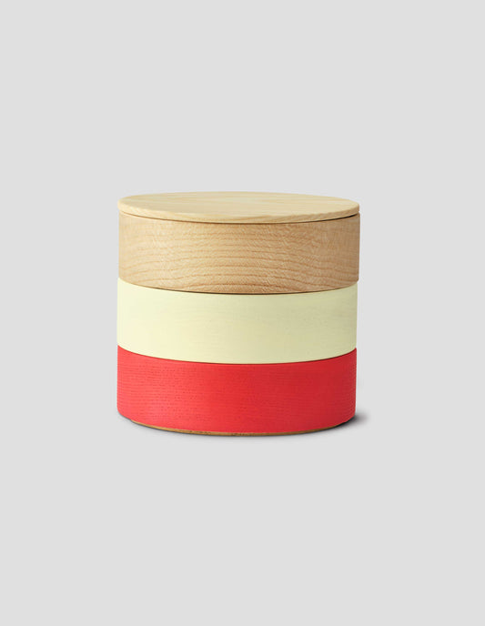 Front flat lay of a round wooden container with light natural wood lid and three stacked colour bands: light wood, cream, and red.
