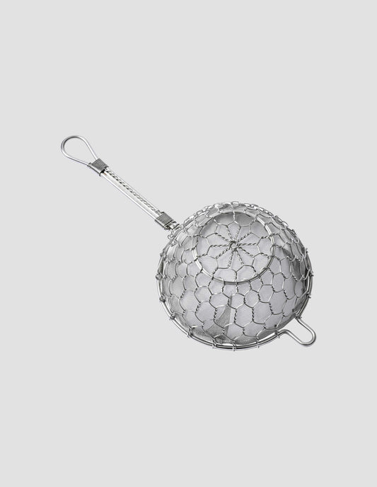 View of the under side of the shiny stainless steel tea strainer showing the detail of the hand twisted Chrysanthemum and tortoiseshell pattern weaving of the wire.