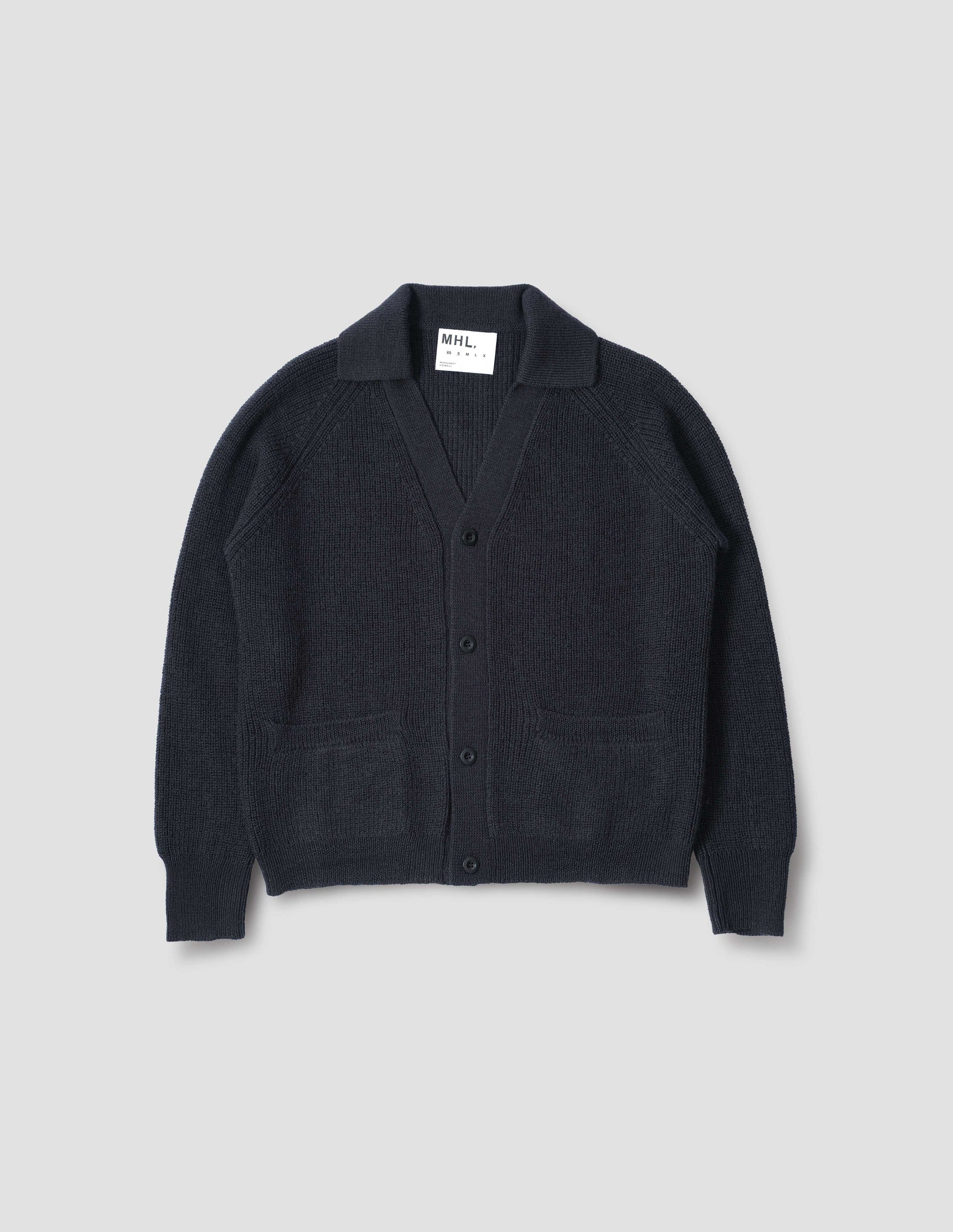 Dark navy blue collared cardigan, with contrast rib on collar, placket, cuff and hem. Finished with corozo button closure and patch pockets. Front flat lay view.