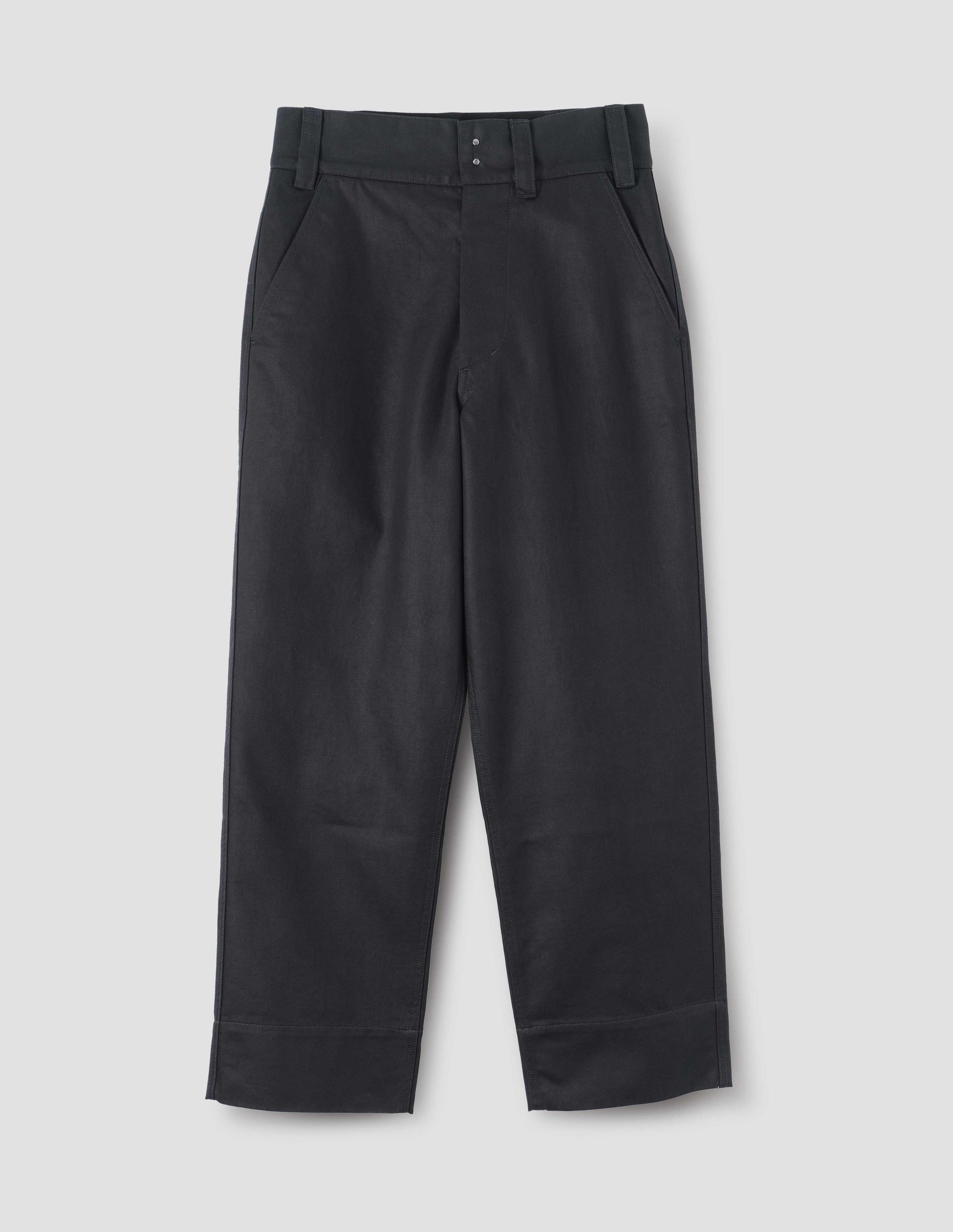 Black cotton trousers, with button-through fly with hook and bar fastening and bearer button, belt loops and slant pockets. Front flat lay view.