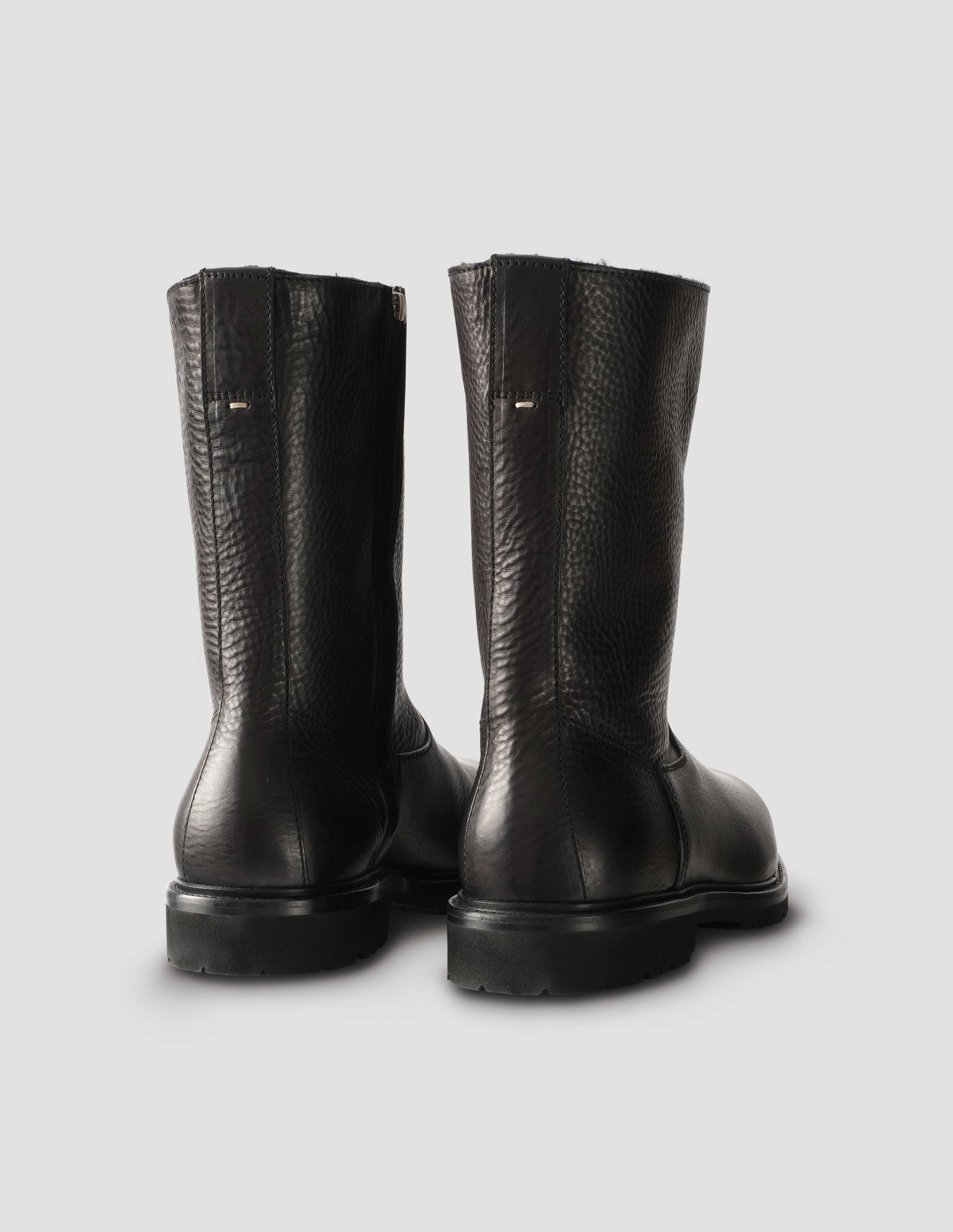 Black leather three quarter length boots with Vibram sole and shearling lining. Back view flat lay.