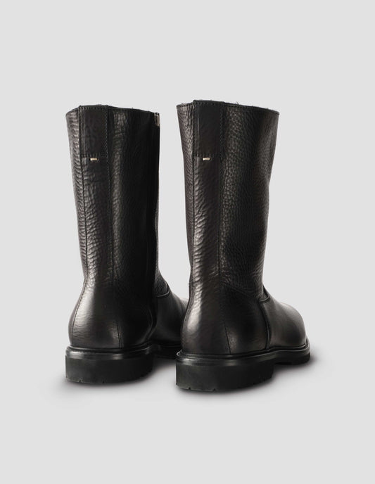 Black leather three quarter length boots with Vibram sole and shearling lining. Back view flat lay.