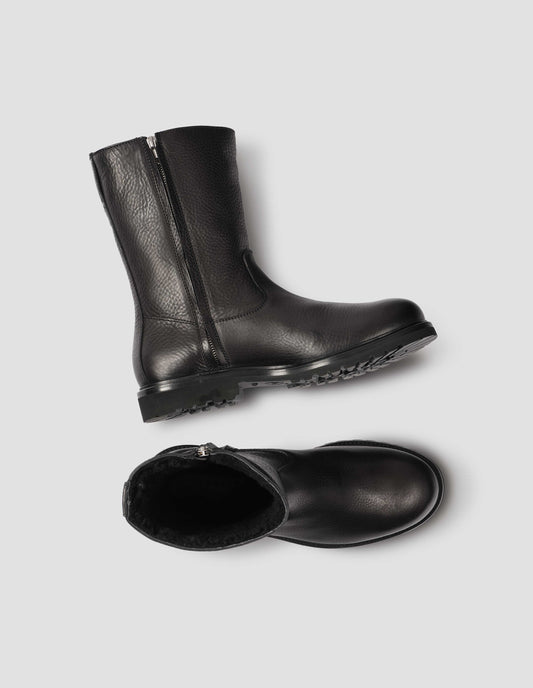 Black leather three quarter length boots with side zip, Vibram sole and shearling lining. View from above flat lay.