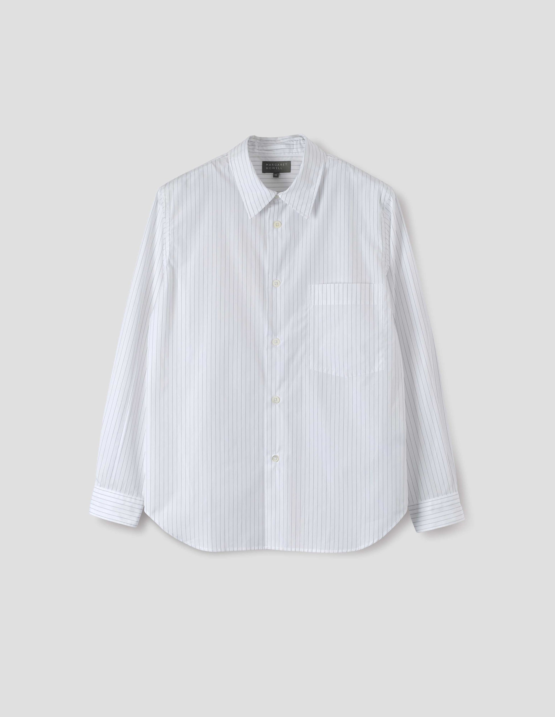 White shirt with grey stripes, chest pocket, mother of pearl buttons and curved hem. Front flat lay view.