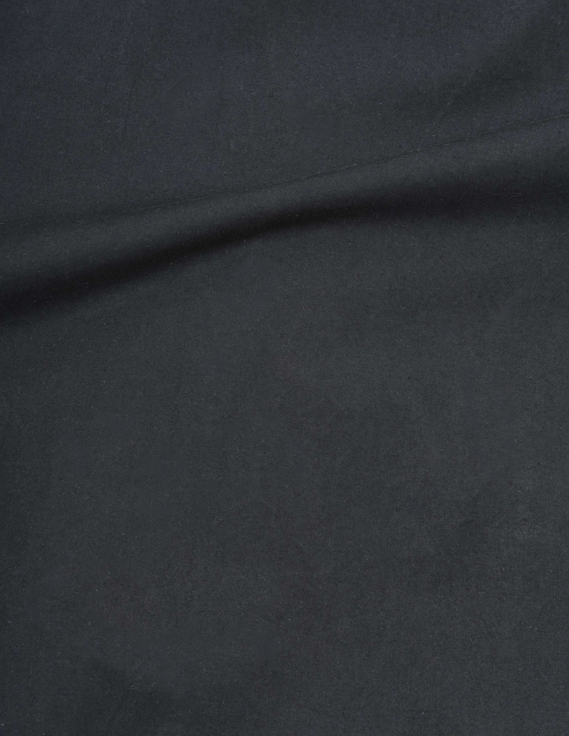 Black dry wax cotton gilet fabric swatch.
