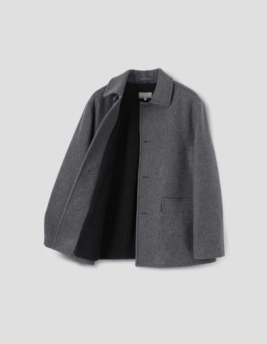 Charcoal grey wool coat with with deep relaxed welt pockets and stitch through detailing. Finished with horn button closure. Front flat lay open view. 